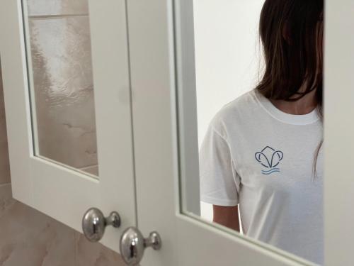 a woman looking at her reflection in a mirror at Villa Incanto Pina - Torre Canne in Torre Canne