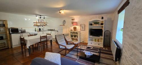 une cuisine et un salon avec une table et des chaises dans l'établissement Gites Ferme de la Baie, à Roz-sur-Couesnon