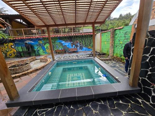 a swimming pool in a house with a mural at Hostal la Divisa Salento in Arrayanal
