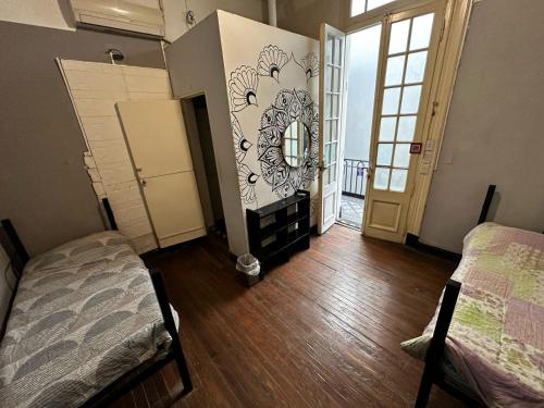 a room with two beds and a mirror on the wall at IDEAL SOCIAL Hostel in Buenos Aires