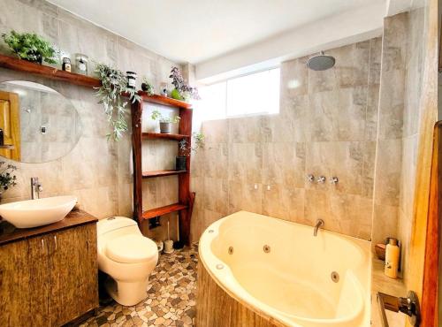 a bathroom with a tub and a toilet and a sink at Pitusiray Sanctuary House in Calca