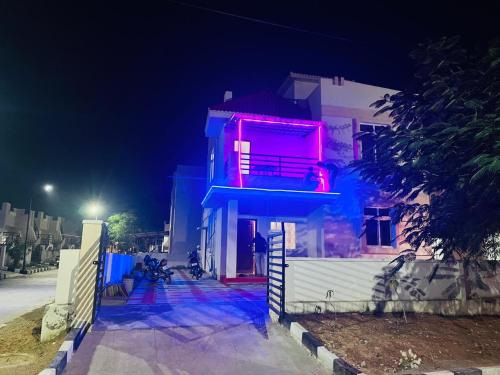 TurkapallyCorporate Hostel & PG的顶部有粉色灯光的建筑物