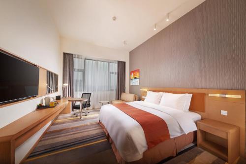 a hotel room with a bed and a flat screen tv at Holiday Inn Express Chengdu Huanhuaxi by IHG-Near Jinsha Site Musem,Near Wuhou Temple Museum,Welcome drinks,Free gym,Free self-service laundry in Chengdu