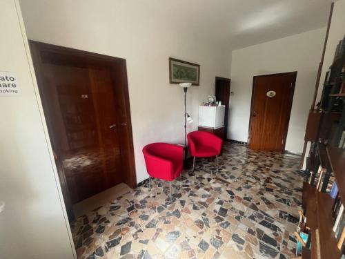 a room with a red chair and a floor at B&B Locanda Pinà - Room 1 in Montemarciano