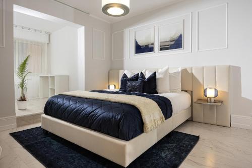 - une chambre blanche avec un grand lit et des oreillers noirs dans l'établissement Qult - Blue Lagoon - 10 min to Casino, à Beausoleil