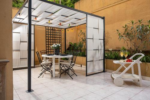 - un pavillon avec une table et des chaises sur la terrasse dans l'établissement Qult - Blue Lagoon - 10 min to Casino, à Beausoleil