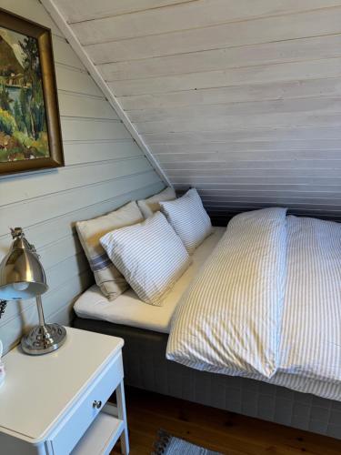 a bed with pillows on it in a room at Charming house located by the fjord with the Pultpitrock within short distance in Strand