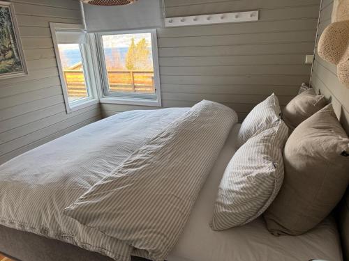a bedroom with a bed with pillows and a window at Charming house located by the fjord with the Pultpitrock within short distance in Strand