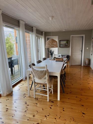 a dining room with a white table and chairs at Charming house located by the fjord with the Pultpitrock within short distance in Strand