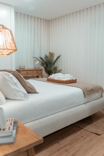 Un dormitorio con una cama blanca grande y una mesa en Rosal Country Village, en Ponte de Lima