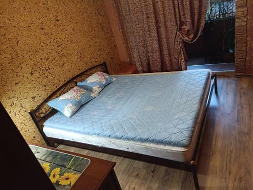 un letto con lenzuola e cuscini blu in una stanza di Покровський район, КРЕС 1,2,3кімнатні, Фрунзе 3к, Зарічний 3к a Kryvyj Rih