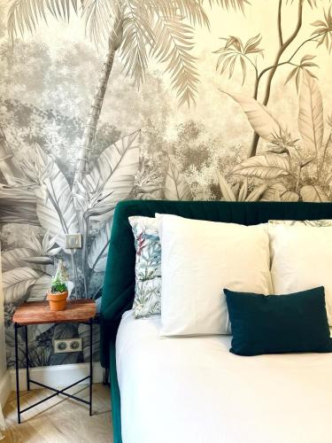 - une chambre avec un lit orné d'une fresque murale de palmiers dans l'établissement Old Town Vibes - 5min to Sea - AC & Breakfast, à Nice