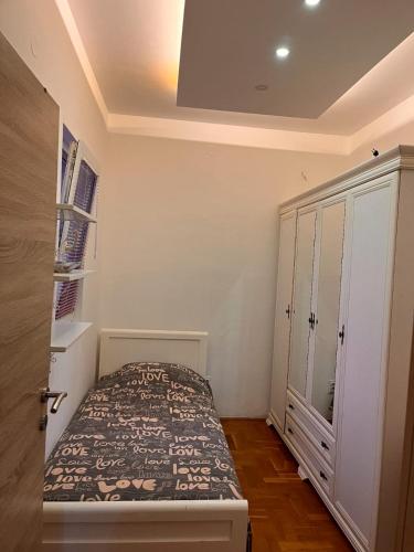 a small bedroom with a bed and a cabinet at Apartman Guberinic,Tivat ,trosoban stan in Tivat