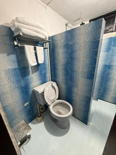 a blue tiled bathroom with a toilet and towels at CasaAZUL in Progreso