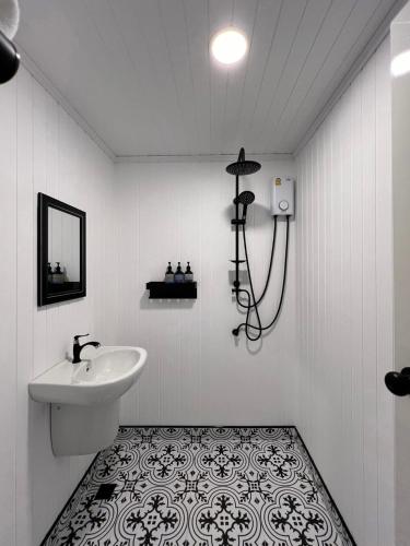 a white bathroom with a sink and a mirror at RaftDara Erawan Resort in Tha Kradan