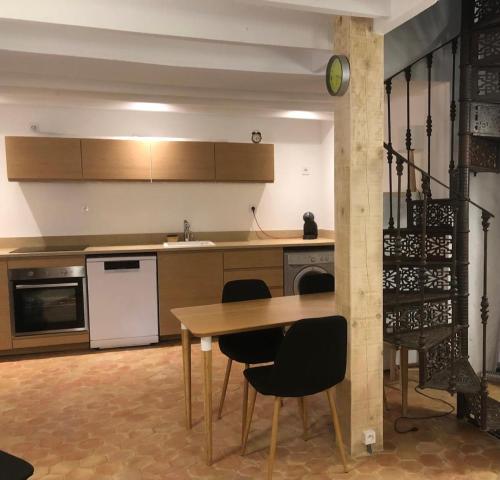 une cuisine avec une table et des chaises dans une pièce dans l'établissement Maison La Paillère, village, à Villeneuve-Loubet