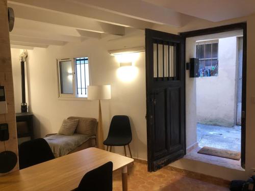 - un salon avec un canapé, une table et une porte dans l'établissement Maison La Paillère, village, à Villeneuve-Loubet