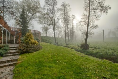 a foggy yard with a house and a grass field at Mlýn Kamenice in Klučenice
