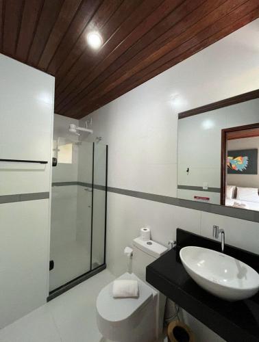 a bathroom with a sink and a toilet and a mirror at Pousada do Canto in Abraão