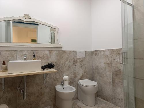 a bathroom with a toilet and a sink and a mirror at John's House in Sanremo