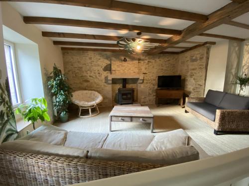 a living room with a couch and a fireplace at Maison l'or du temps gite Les Vignes in La Boissière-de-Montaigu