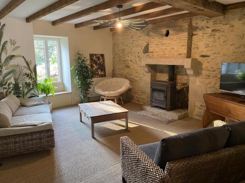 a living room with a couch and a fireplace at Maison l'or du temps gite Les Vignes in La Boissière-de-Montaigu