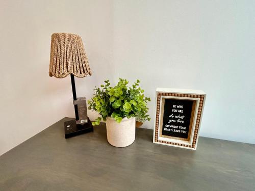 a table with a lamp and a plant and a chalkboard at New Lux Skyline Loft in LA in North Sherman Way
