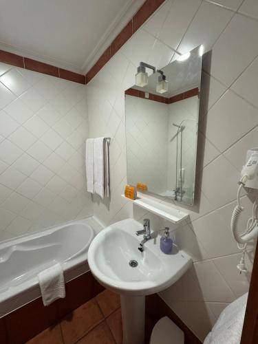 a white bathroom with a sink and a tub at Casa Santa Catarina in Montalegre