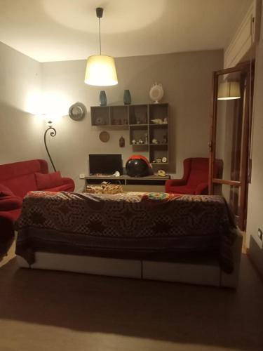 a bedroom with a bed and two red chairs at Dimora La Fenice in Licola