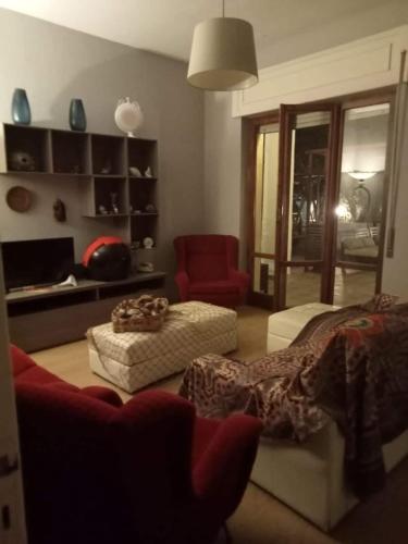 a living room with a couch and a red chair at Dimora La Fenice in Licola