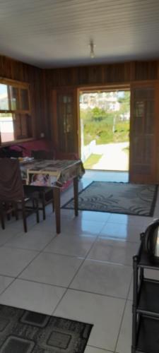 a living room with a table and a view of a yard at Casa de praia em garopaba sc in Garopaba
