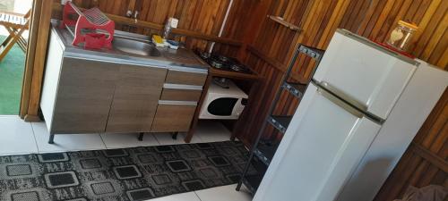a small kitchen with a sink and a refrigerator at Casa de praia em garopaba sc in Garopaba