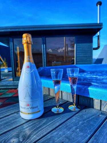 a bottle of wine and two glasses on a table at PRIVATE PLACE Avrig adults only in Avrig