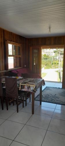 a living room with a table and a couch at Casa de praia em garopaba sc in Garopaba