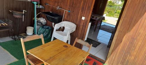 a wooden table and two chairs sitting in a room at Casa de praia em garopaba sc in Garopaba