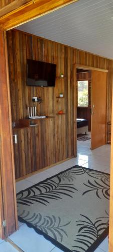 a room with wooden walls and a large rug at Casa de praia em garopaba sc in Garopaba