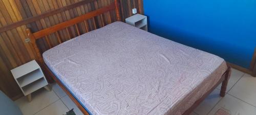 a small bed in a room with a purple blanket at Casa de praia em garopaba sc in Garopaba
