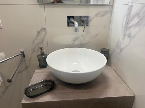 a bathroom with a white bowl sink on a counter at Slow Chic Apartment Papardo in Messina