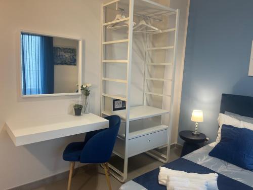 a bedroom with a desk and a bed and a blue chair at Slow Chic Apartment Papardo in Messina
