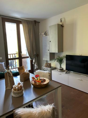 a living room with a table with a bowl of fruit at Maison Du Coeur Champoluc - Spa, Gym e aree relax in Champoluc