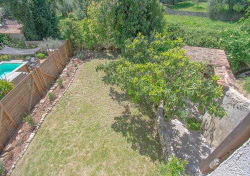 a garden with a tree and a fence at Chez Germaine et Constant 6 pers grand jardin in Seillans