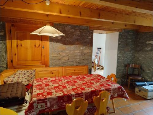 a dining room with a table with a quilt on it at La Baita di Savara - nature and silence in Valsavarenche