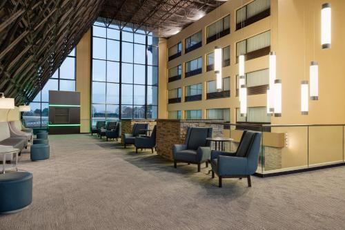 an office lobby with chairs and tables and windows at Holiday Inn Virginia Beach - Norfolk by IHG in Virginia Beach
