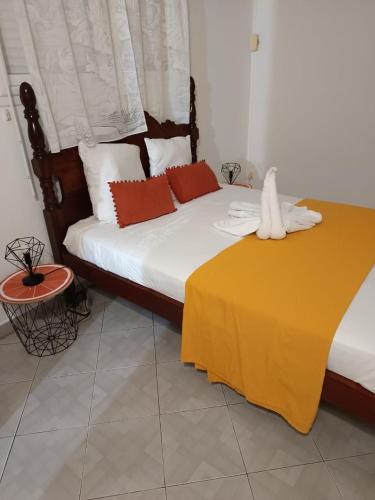 a bed with red and white pillows in a room at Maison la Casa Créole, spa, emplacement central in Les Abymes