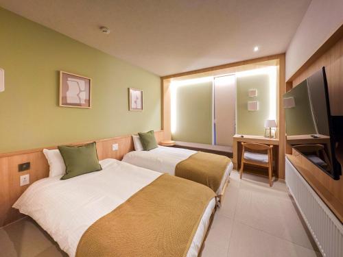 a hotel room with two beds and a flat screen tv at Hotel Login Niseko - Vacation STAY 04013v in Kutchan