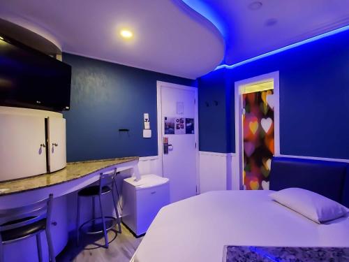 a blue room with a bed and a counter at Lina Motel Tatuapé in Sao Paulo
