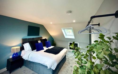 a bedroom with a bed with blue walls and a plant at Sapphire Quarters, 3BR, En Suite, Private Parking in Hindlip