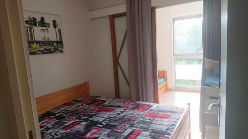 une chambre avec un lit avec une couette dessus dans l'établissement App le palais d'été, à Argelès-sur-Mer