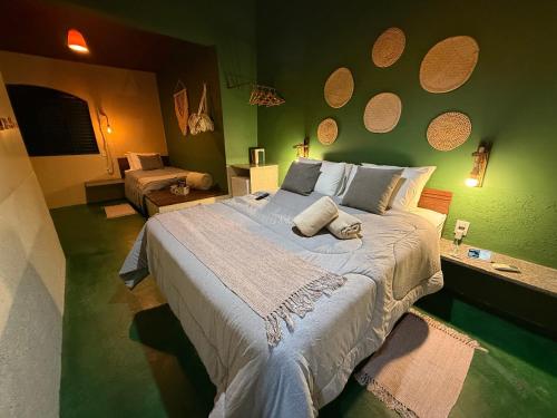 a bedroom with a large bed with green walls at Dona Nilza Hotel Fazenda in Brasilia