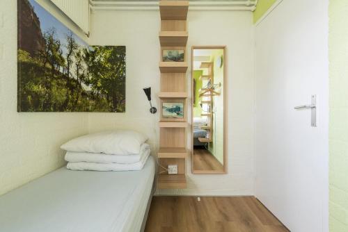 a small bedroom with a bed and a mirror at Saffier Zuid-Limburg in Simpelveld